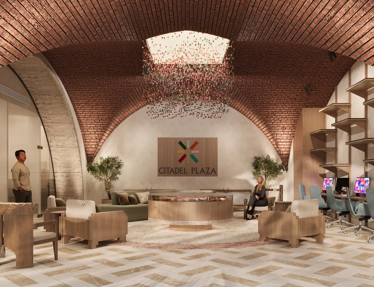 Citadel Plaza Sales Office – Central view of the logo wall and round desk beneath brick vaults